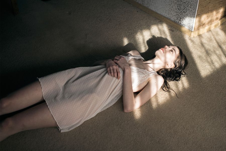 woman laying in sun spot on floor