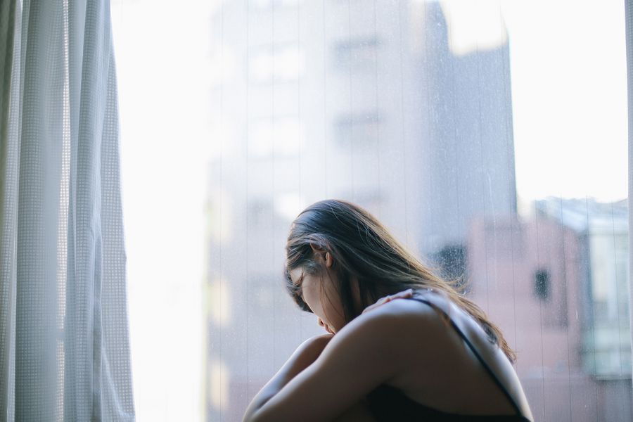 lonely woman sitting by window