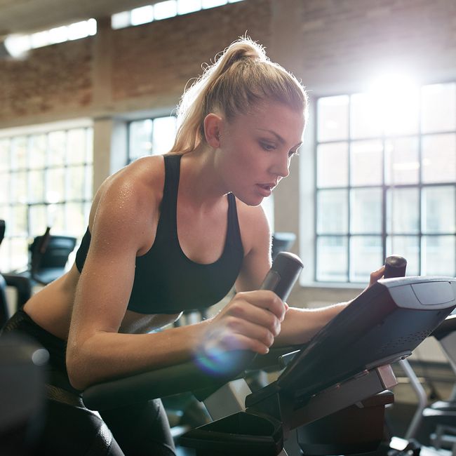 woman doing hiit on spin bike to increase metabolism